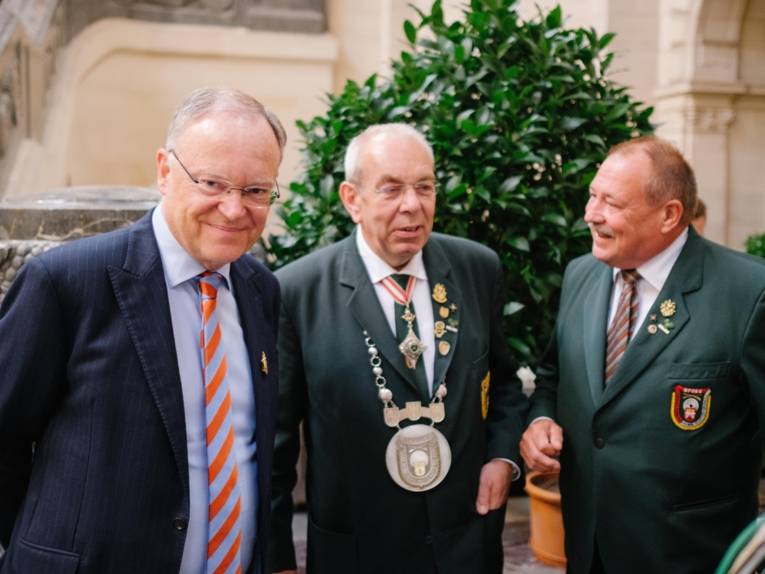 Drei Männer in einer Halle.